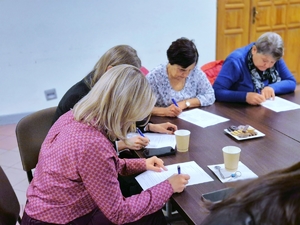 Seniorzy wypełniający ankiety.