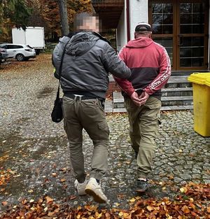 Policjant doprowadzający zatrzymanego.