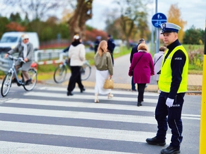 Policjant kierujący ruchem przy przejściu dla pieszych.