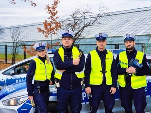 Policjanci ruchu drogowego przy radiowozie.