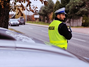 Policjant ruchu drogowego podczas pomiaru prędkości.