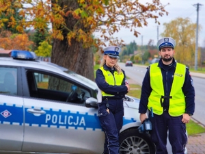 Policjanci ruchu drogowego przy radiowozie.