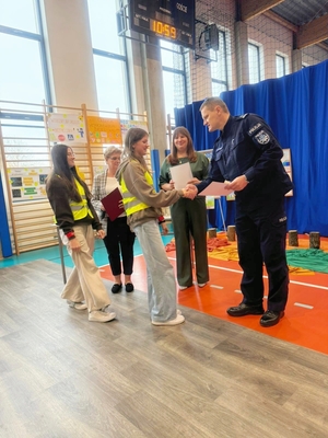 I Zastępca Komendanta Miejskiego Policji w Skierniewicach wręczający nagrody.