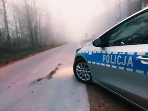 Radiowóz a w tle mgła.