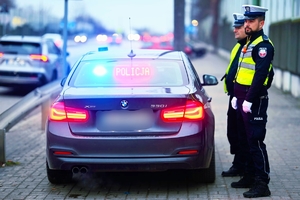Policjanci ruchu drogowego prz nieoznakowanym radiowozie.