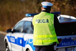Policjant przy radiowozie.