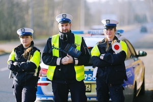 Policjanci ruchu drogowego przy radiowozie.
