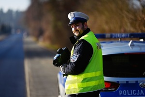 Policjant ruchu drogowego przy radiowozie.