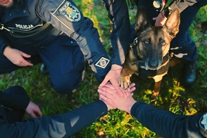 Policyjny pies z policjantami.