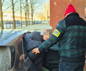 Funkcjonariusz z zatrzymanym przy aucie.