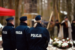 Policjanci a w tle pomnik.