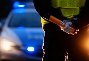 Policjantka trzymająca urządzenie do pomiaru alkoholu w wydychanym powietrzu.