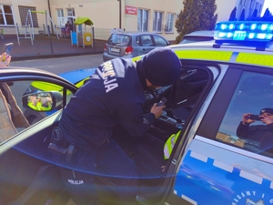 Policjant przy radiowozie.