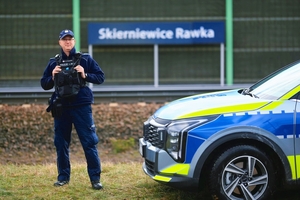 Dzielnicowy przy radiowozie.