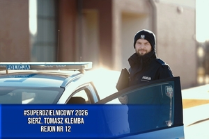 Dzielnicowy przy radiowozie.