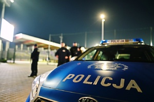 Radiowóz na tle stadionu.