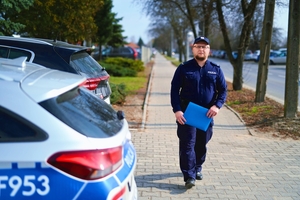 Dzielnicowy przy radiowozie.