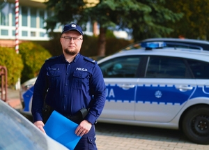 Dzielnicowy przy radiowozie.