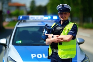 Policjant przy radiowozie.