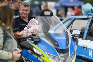 Policjant z dzieckiem na motocyklu.