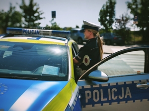 Policjantka przy radiowozie.