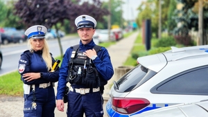 Policjanci obok radiowozu.