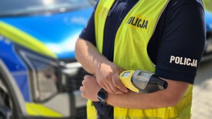 Policjant trzymający urządzenie do pomiaru trzeźwości.