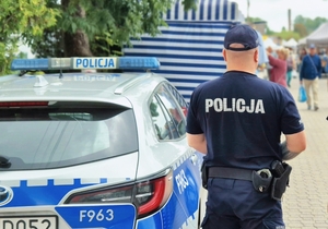 Policjant przy radiowozie.
