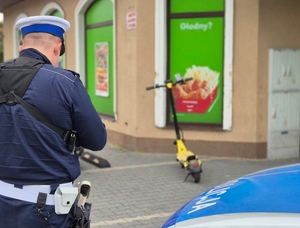 Policjant a w tle hulajnoga.