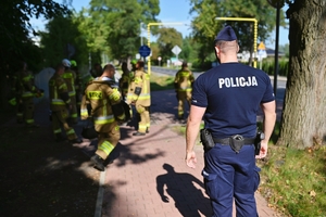 Policjant ze strażakami.