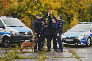 Policjanci przy radiowozach.