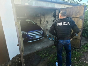 Policjant przy odnalezionym pojeździe.