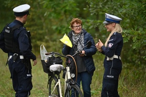 Policjanci rozdający kamizelki rowerzystom.