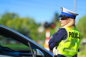 Policjantka a w tle przejazd kolejowy.