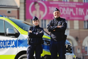 Policjanci wydziału prewencji przy radiowozie.